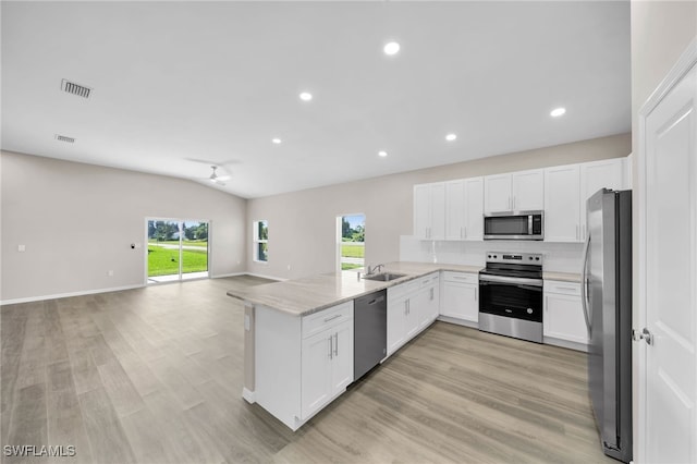 kitchen featuring kitchen peninsula, appliances with stainless steel finishes, light hardwood / wood-style flooring, and white cabinetry