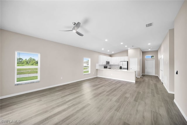 unfurnished living room featuring a wealth of natural light, light hardwood / wood-style flooring, and ceiling fan