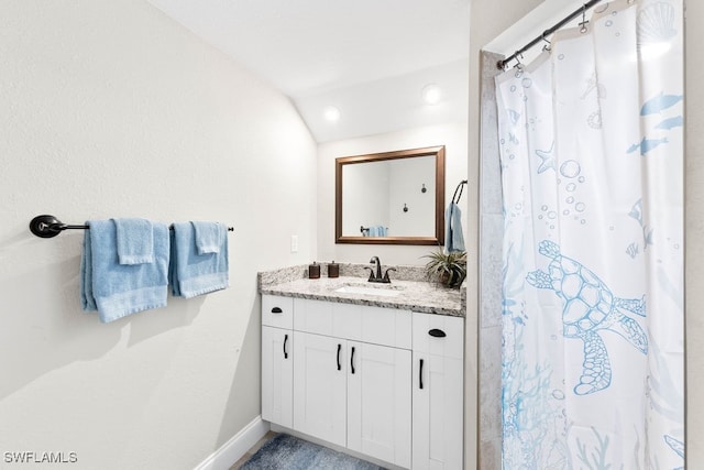 bathroom featuring vanity and lofted ceiling