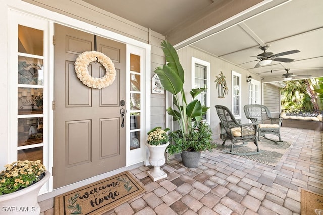 entrance to property featuring ceiling fan and a porch