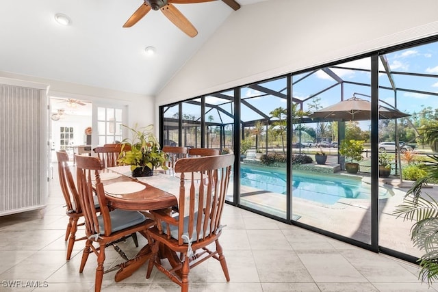 dining area featuring ceiling fan, light tile patterned floors, and high vaulted ceiling