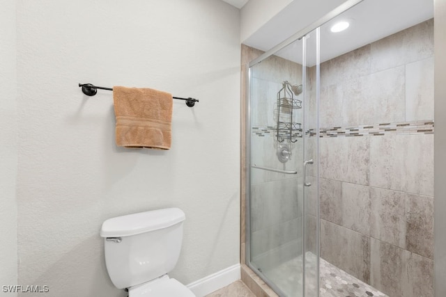 bathroom featuring toilet and an enclosed shower