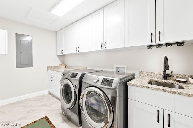 clothes washing area featuring electric panel, sink, cabinets, and washing machine and dryer