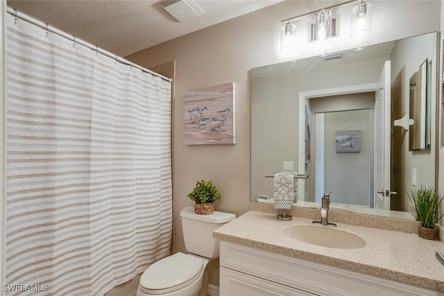 bathroom featuring vanity, curtained shower, and toilet