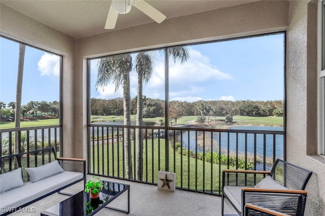 sunroom with a water view and ceiling fan