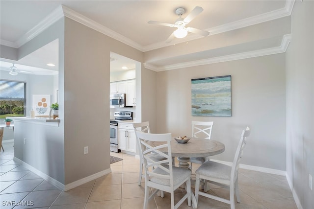 tiled dining room with ceiling fan and ornamental molding