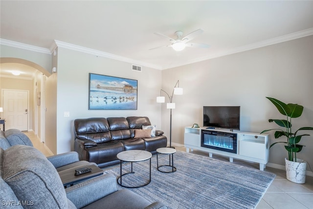 tiled living room with ceiling fan and ornamental molding