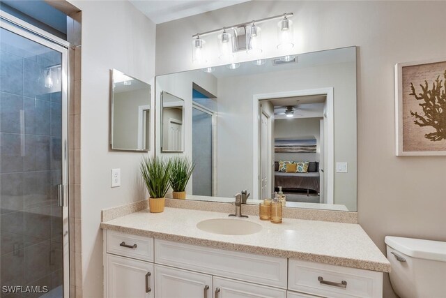 bathroom featuring an enclosed shower, vanity, and toilet