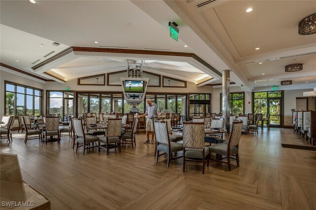 dining area with crown molding, plenty of natural light, high vaulted ceiling, and parquet flooring