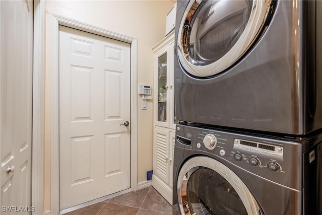 laundry area featuring cabinets and stacked washer and clothes dryer