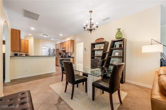 dining area with light tile patterned floors and an inviting chandelier