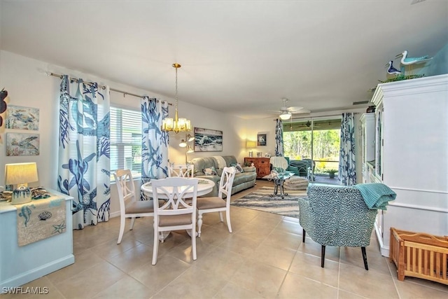 dining area with a wealth of natural light, light tile patterned floors, and ceiling fan with notable chandelier