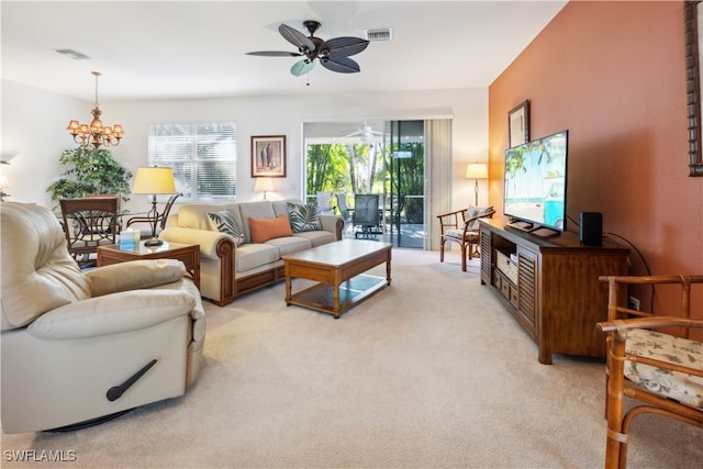 carpeted living room with ceiling fan with notable chandelier