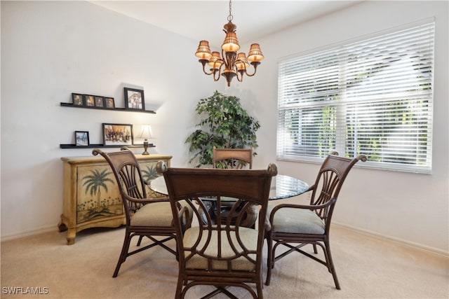 carpeted dining area with a chandelier