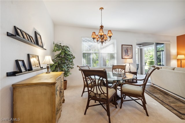 dining area featuring light carpet and a notable chandelier