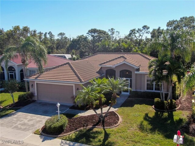 mediterranean / spanish home with a front yard and a garage