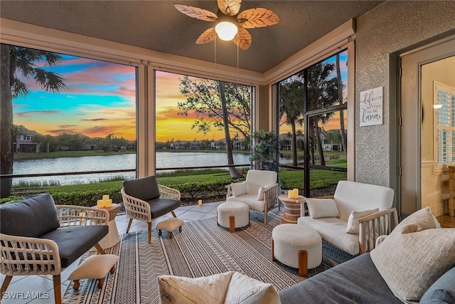 sunroom with a water view and ceiling fan