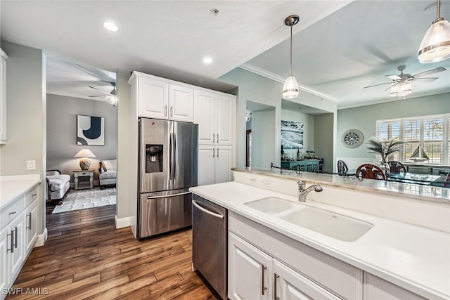 9229 Museo Cir Unit 102, Naples, FL 34114 - kitchen featuring appliances with stainless steel finishes, a ceiling fan, a sink, ornamental molding, and hanging light fixtures