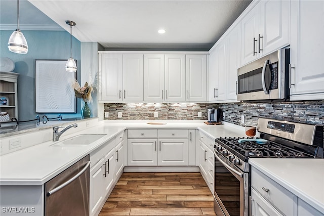 kitchen featuring sink, white cabinets, ornamental molding, and appliances with stainless steel finishes