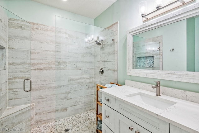 bathroom with vanity and a shower with shower door