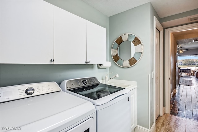 laundry room with cabinets, ceiling fan, sink, separate washer and dryer, and light hardwood / wood-style flooring