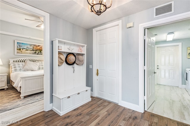 mudroom featuring hardwood / wood-style flooring, ceiling fan with notable chandelier, and a textured ceiling