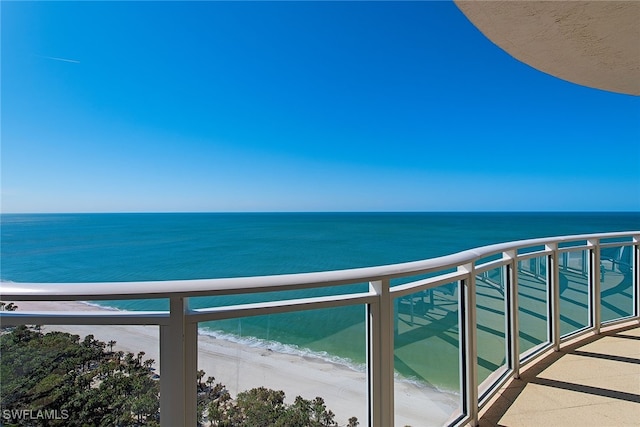 balcony with a water view and a beach view