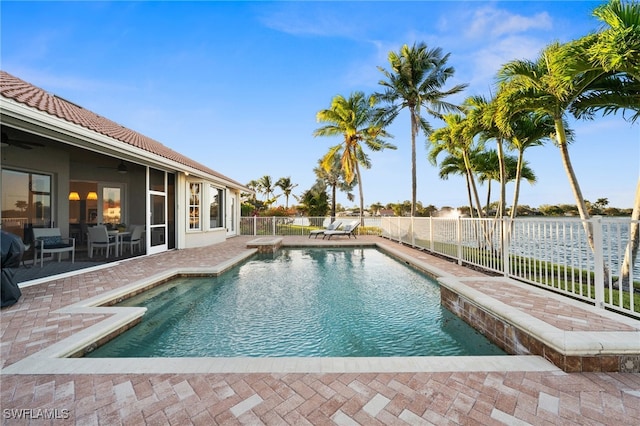 view of swimming pool with a patio and a water view