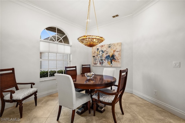 dining area with ornamental molding, light tile patterned floors, and a chandelier