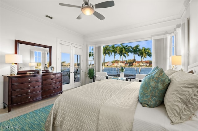 bedroom with french doors, light wood-type flooring, access to outside, ceiling fan, and a water view