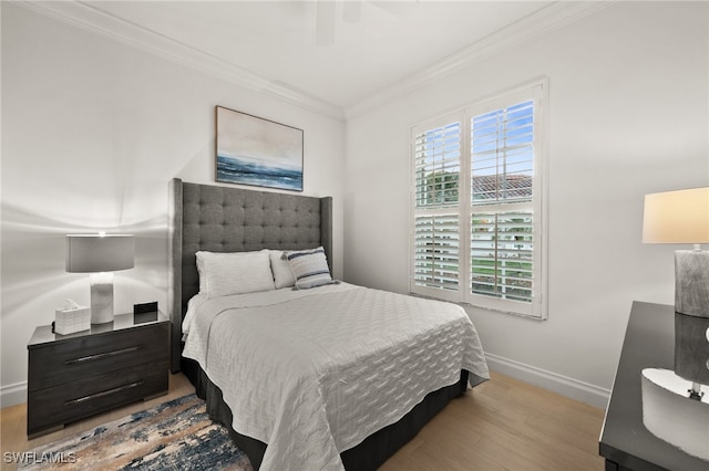 bedroom featuring light hardwood / wood-style floors, ceiling fan, and ornamental molding