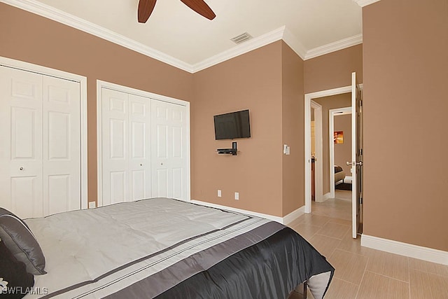 bedroom with multiple closets, ceiling fan, and crown molding