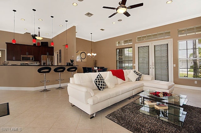 living room with ceiling fan with notable chandelier, ornamental molding, and light tile patterned floors