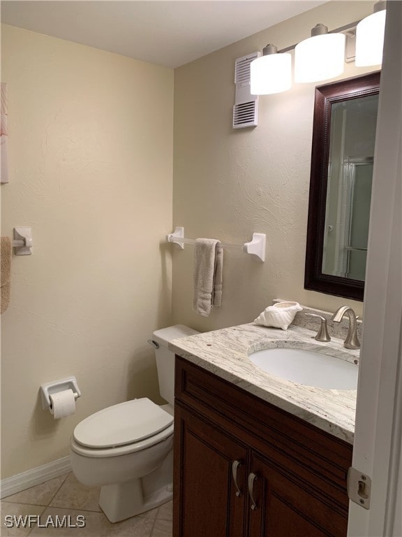 bathroom with toilet, vanity, tile patterned floors, and an enclosed shower