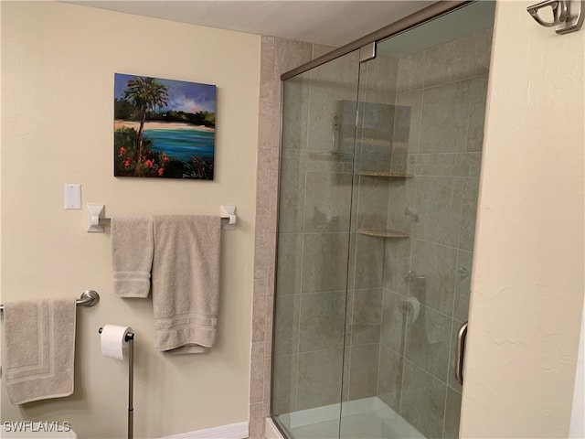 bathroom with a shower with door