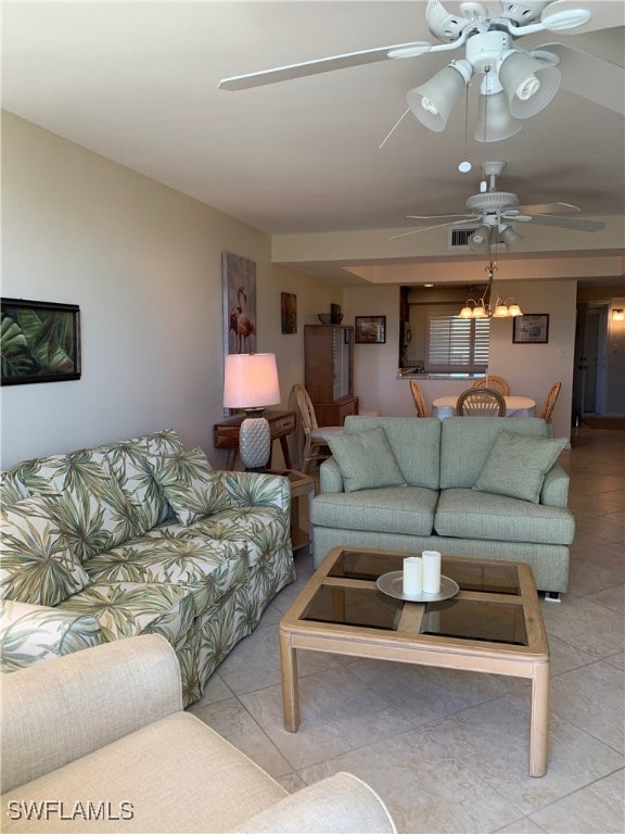 living room featuring light tile patterned floors and ceiling fan with notable chandelier