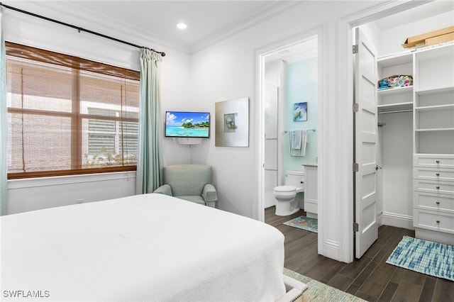 bedroom featuring dark hardwood / wood-style floors, crown molding, connected bathroom, and a closet