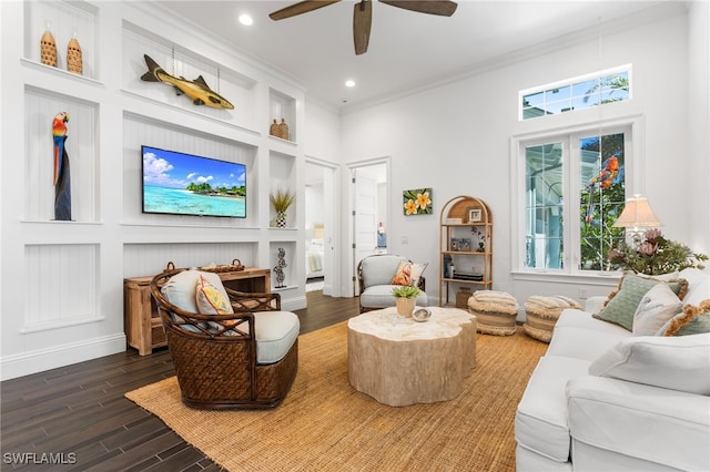 living room featuring dark hardwood / wood-style flooring, ornamental molding, a high ceiling, and a wealth of natural light