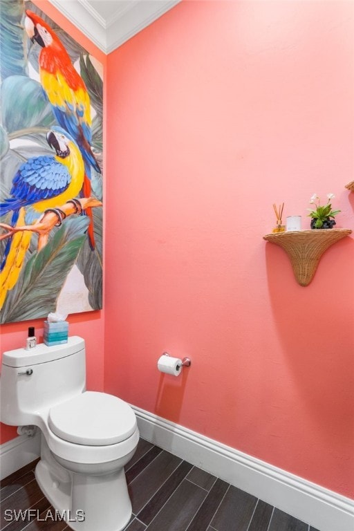 bathroom featuring hardwood / wood-style floors, toilet, and crown molding