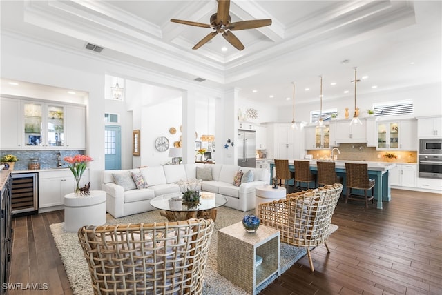 living room featuring dark hardwood / wood-style floors, a towering ceiling, crown molding, and wine cooler