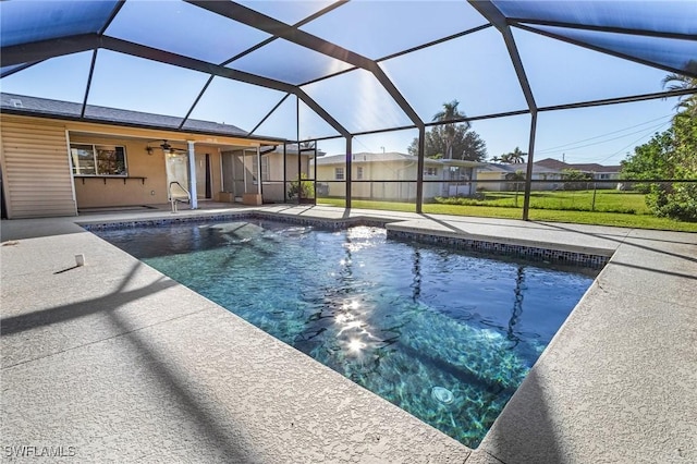 view of pool with ceiling fan, a lanai, and a patio