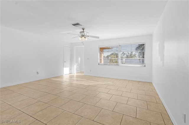 tiled spare room featuring ceiling fan