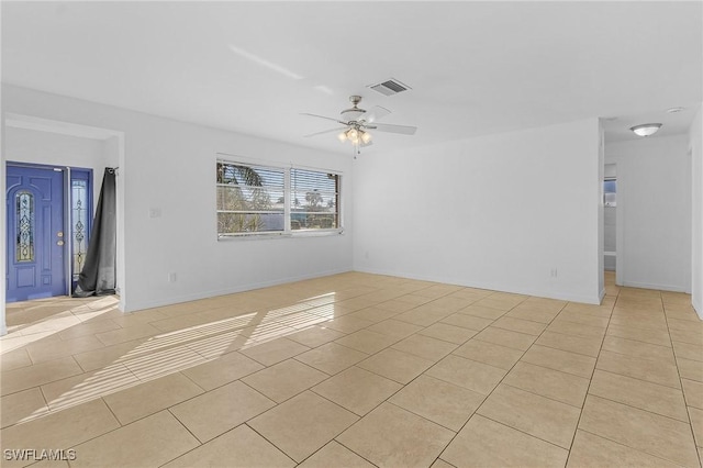 tiled empty room featuring ceiling fan