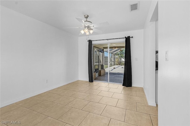 empty room with ceiling fan and light tile patterned floors