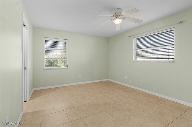 tiled spare room with ceiling fan and a healthy amount of sunlight