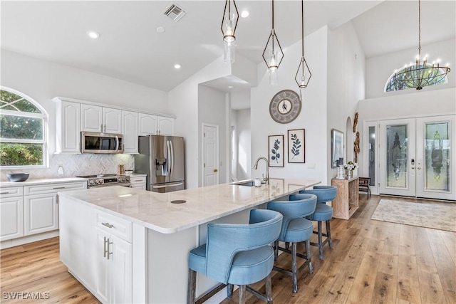 kitchen featuring white cabinets, a large island with sink, and stainless steel appliances