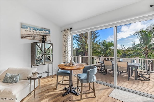 dining area featuring hardwood / wood-style floors and vaulted ceiling