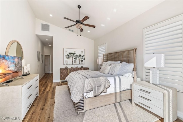 bedroom featuring ceiling fan, hardwood / wood-style floors, and high vaulted ceiling