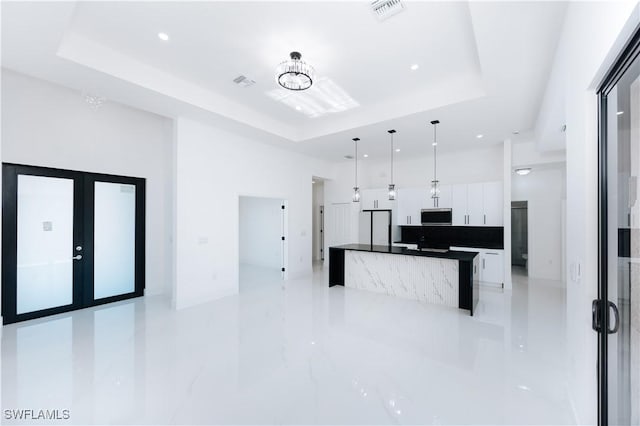 kitchen featuring white cabinets, pendant lighting, white refrigerator, and a raised ceiling