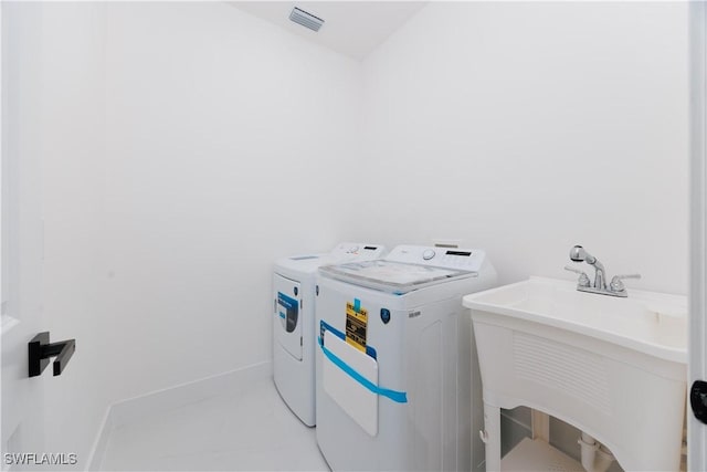 clothes washing area featuring washing machine and clothes dryer and sink